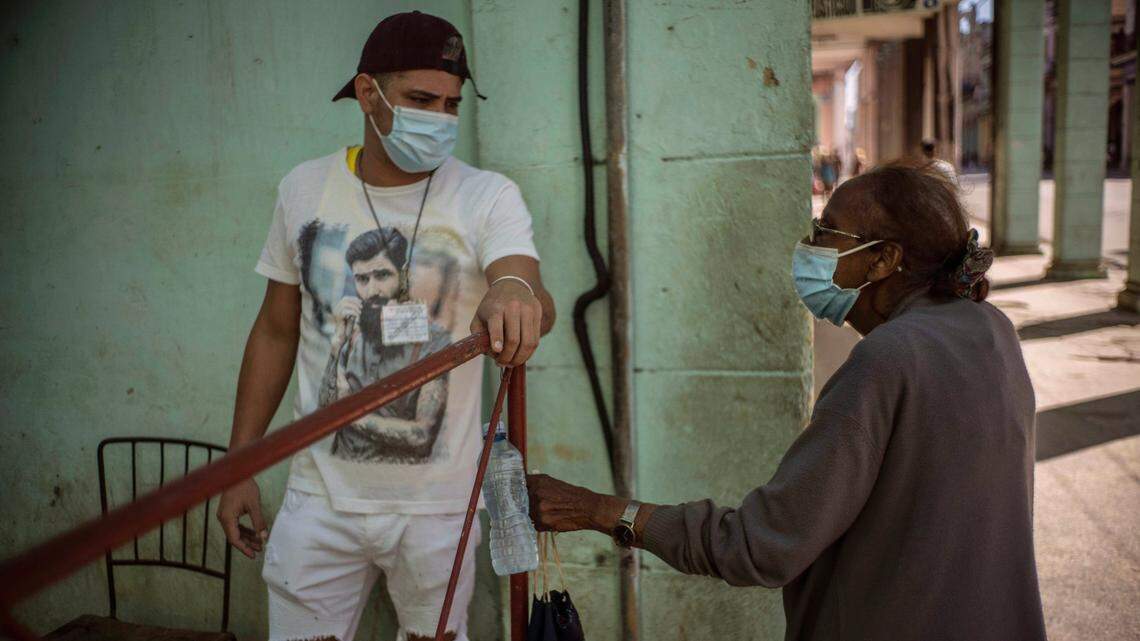 Un hombre hace guardia en una puerta que corta el acceso a un vecindario para mantener alejados a quienes no viven allí, como una forma de frenar la propagación de la pandemia de COVID-19 en La Habana, Cuba, el lunes 22 de febrero de 2021. (Foto AP / Ramon Espinosa)