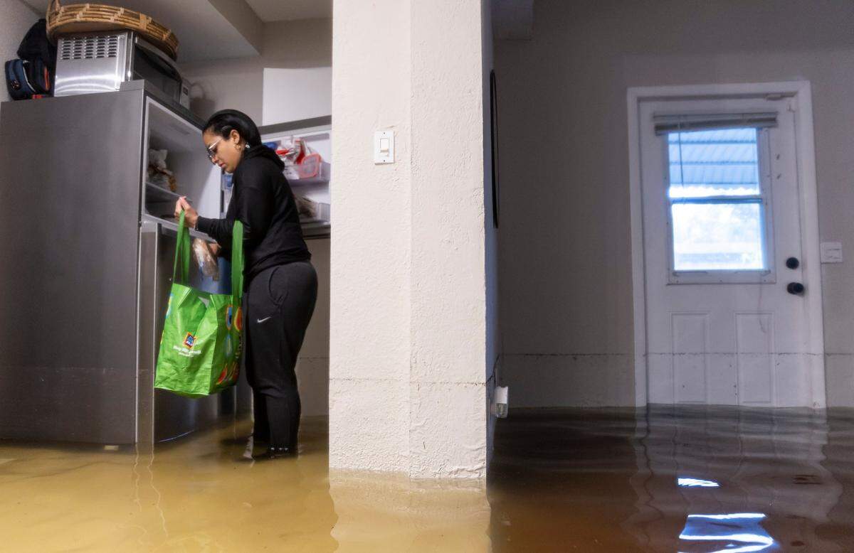 Denis Méndez, de 32 años, empaca alimentos mientras está dentro de su casa parcialmente sumergida en el vecindario de Edgewood el jueves 13 de abril de 2023 en Fort Lauderdale, Florida. Un aguacero torrencial inundó severamente calles sumergiendo parcialmente casas y automóviles en todo el sur de Florida.