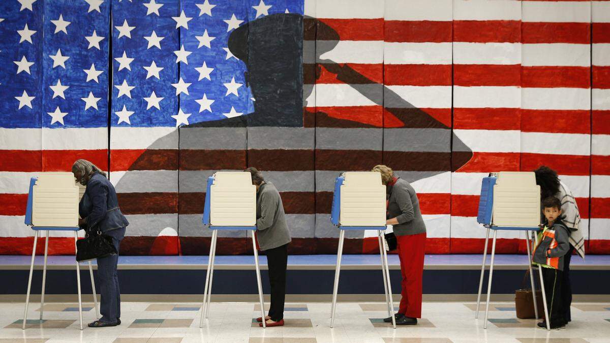 Cuatro personas votan en las elecciones presidenciales el 8 de noviembre de 2016, en la Escuela Elementaria Robious en Richmond, Virginia.