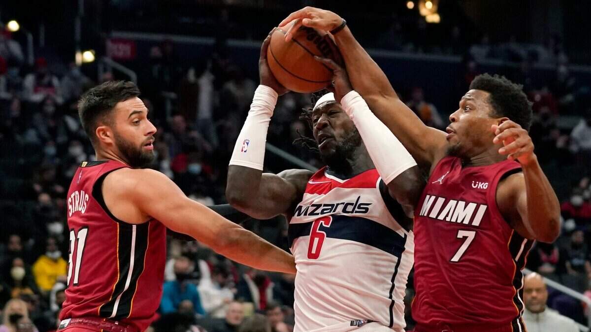 Los jugadores del Heat de Miami Max Strus (izq.) y Kyle Lowry (7) defienden ante el centro de los Wizards Montrezl Harrell, en el partido celebrado el 7 de febrero de 2022 en Washington.