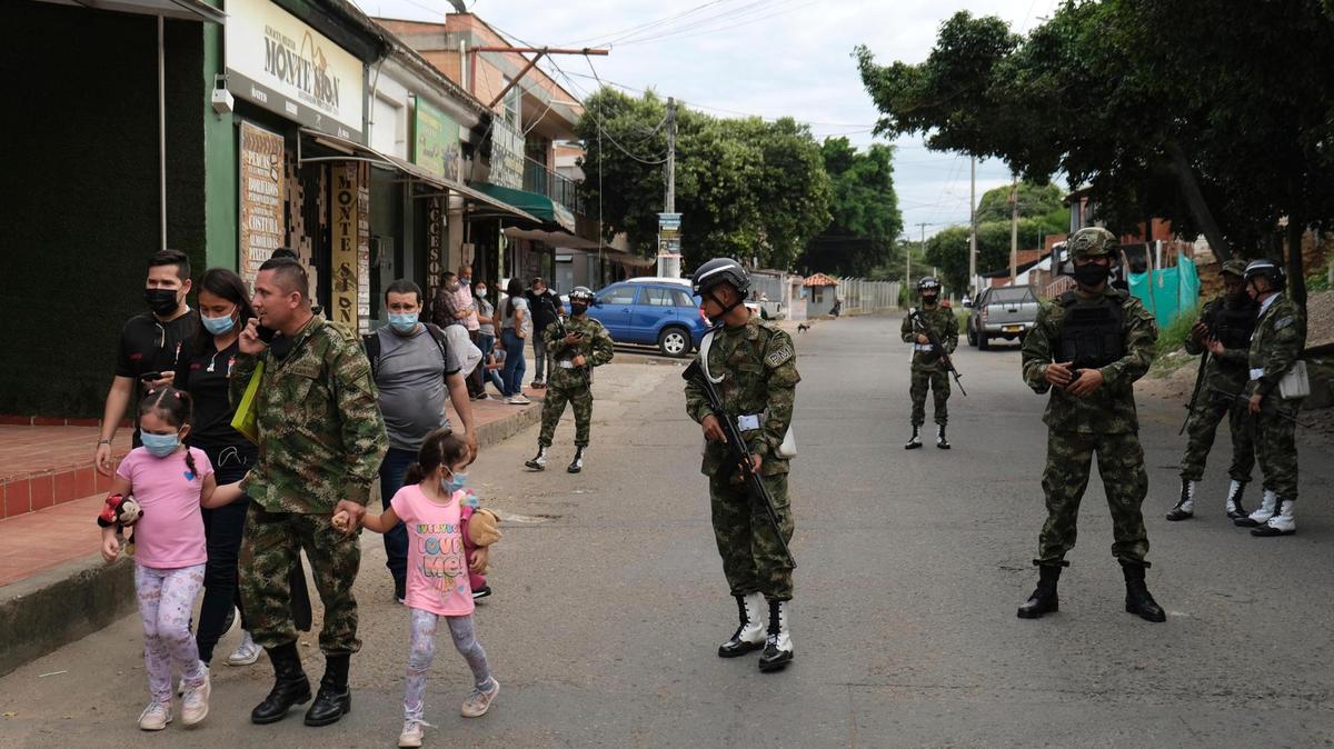 Un soldado camina con su familia cerca de la base militar donde explotó un coche bomba en Cúcuta, Colombia, el martes 15 de junio de 2021. Las autoridades dijeron que 36 personas resultaron heridas, incluidas tres en estado crítico.  