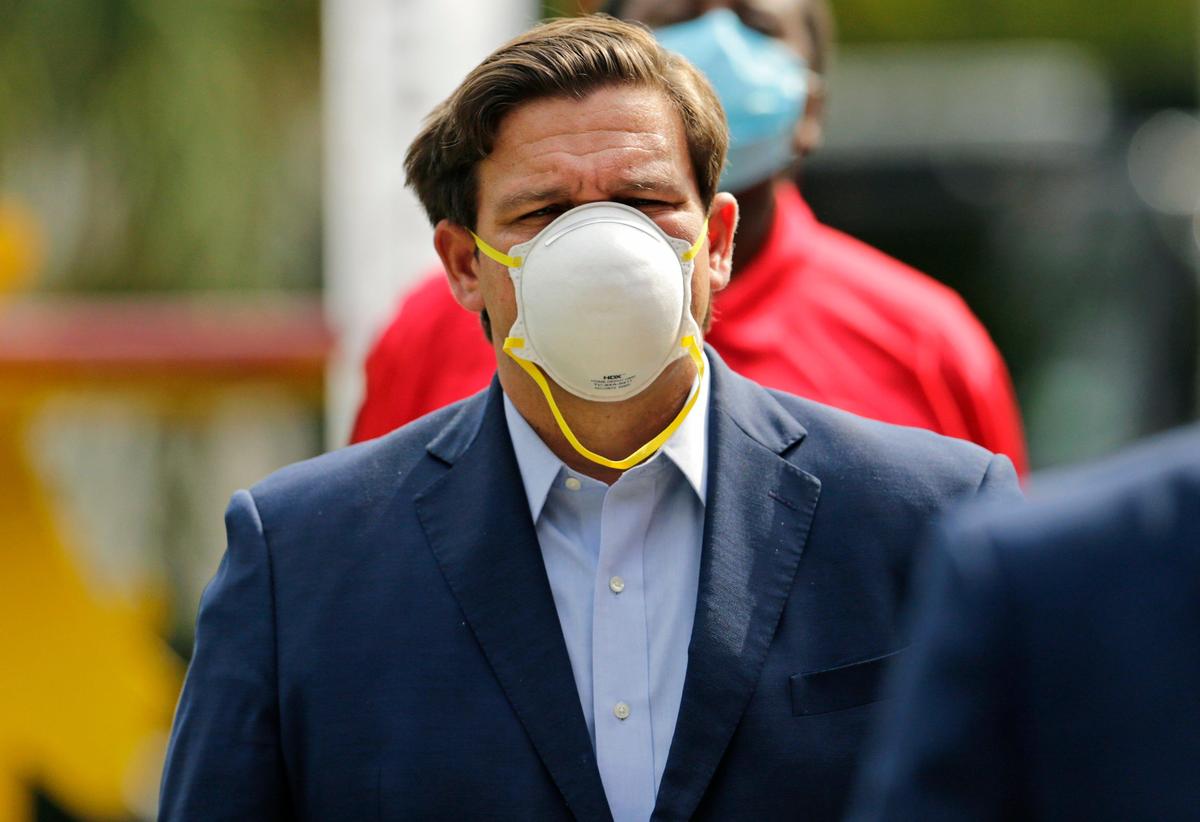 El gobernador de Florida, Ron DeSantis, usa una máscara protectora durante una conferencia de prensa en la Liga Urbana del Condado de Broward en Fort Lauderdale el viernes 17 de abril de 2020.