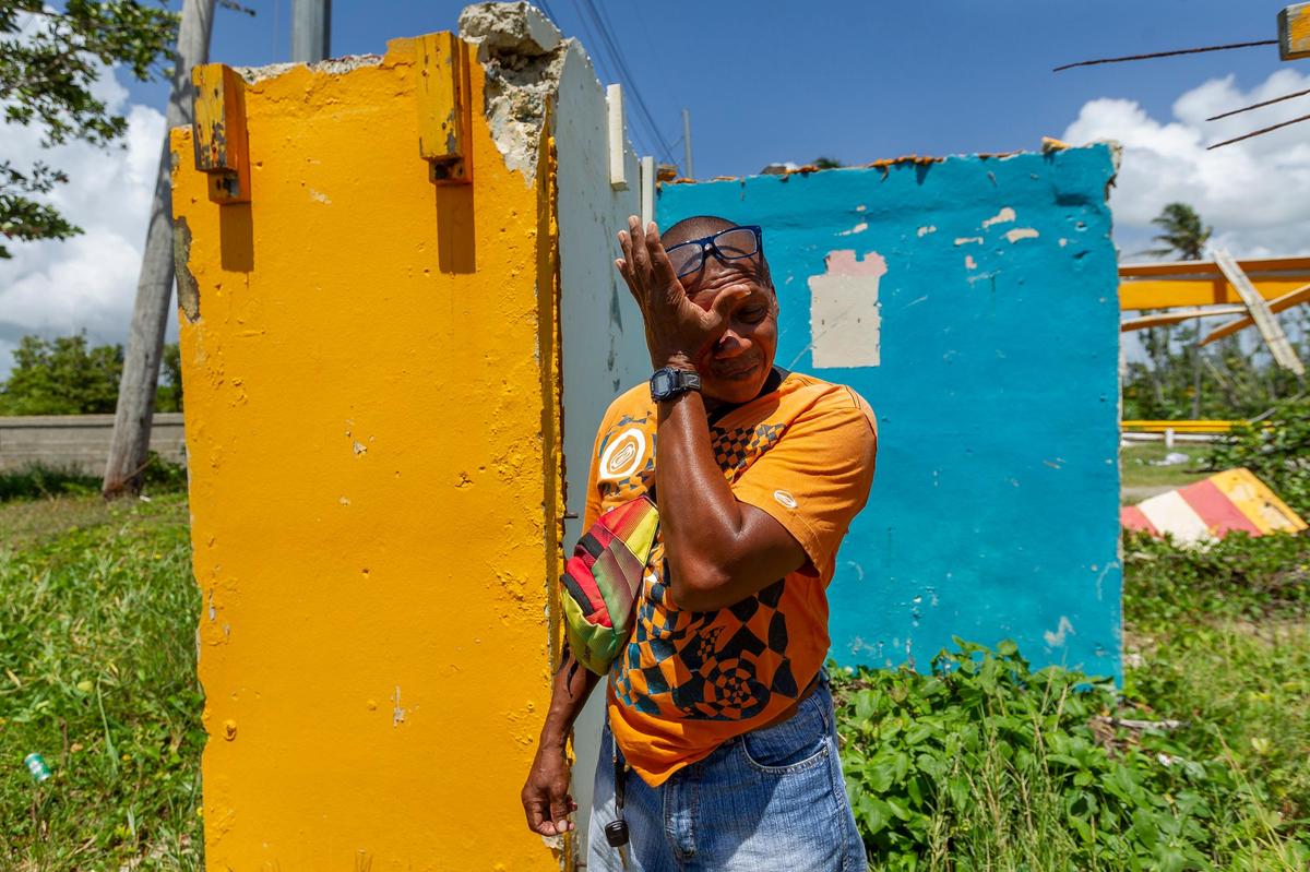 José Luis Aponte Cruz, de 52 años, se enjuga las lágrimas mientras camina por entre las ruinas de su Kiosko El Amarillo en Punta Santiago, comunidad de Humacao, Puerto Rico. El negocio quedó destruido el año pasado con el paso del huracán María.