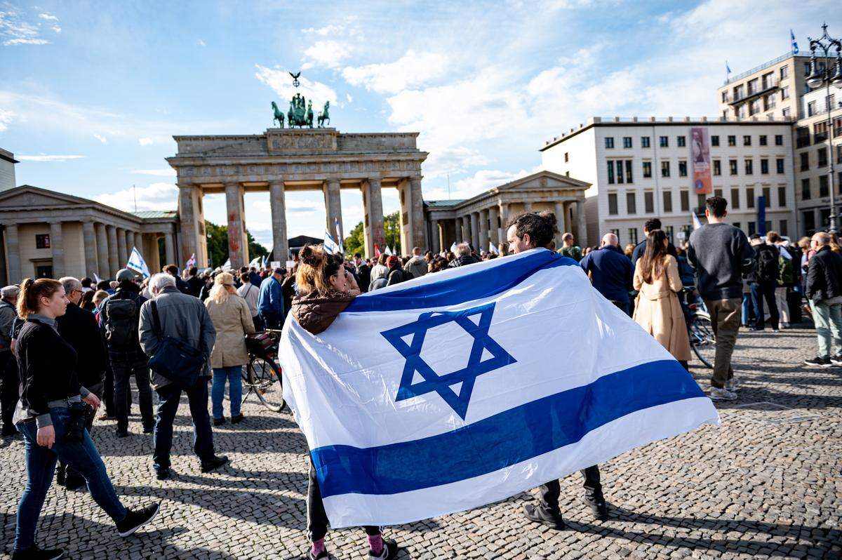 Dos personas sostienen una bandera de Israel durante una manifestación en solidaridad con el pueblo israelí, el domingo 8 de octubre de 2023, en Berlín.