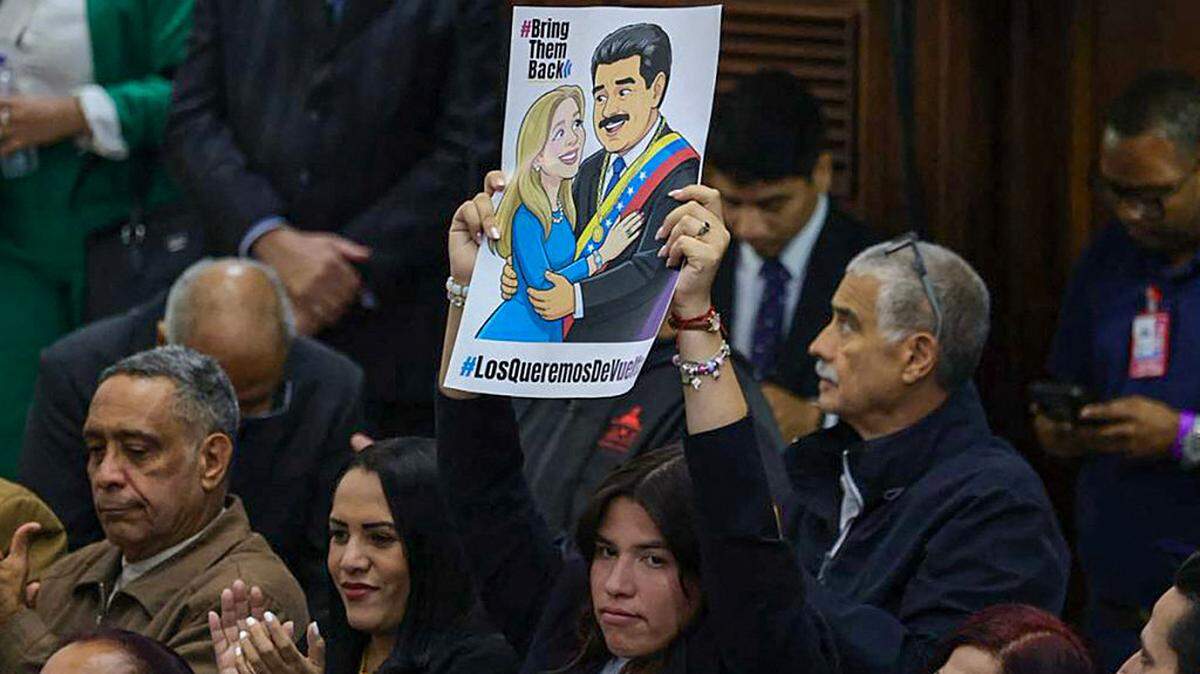 Una diputada muestra un cartel que representa al gobernante depuesto de Venezuela, Nicolás Maduro, y a su esposa, Cilia Flores, antes de una sesión en la Asamblea Nacional en Caracas, el jueves 26 de marzo de 2026.