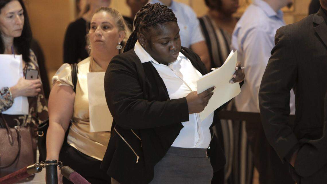 In 2019, Kathy Versane fills out a job application while in line at a South Florida job fair.