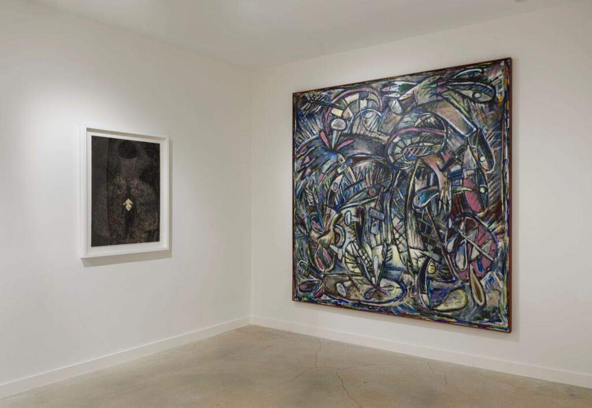 Una pintura de Alfonzo, “Sed”, junto a un grabado de Ayón que representa a una mujer quitándose una máscara. La pintura de Alfonzo ejemplifica su obra posterior, más oscura, de la época anterior a su muerte por complicaciones del SIDA. 