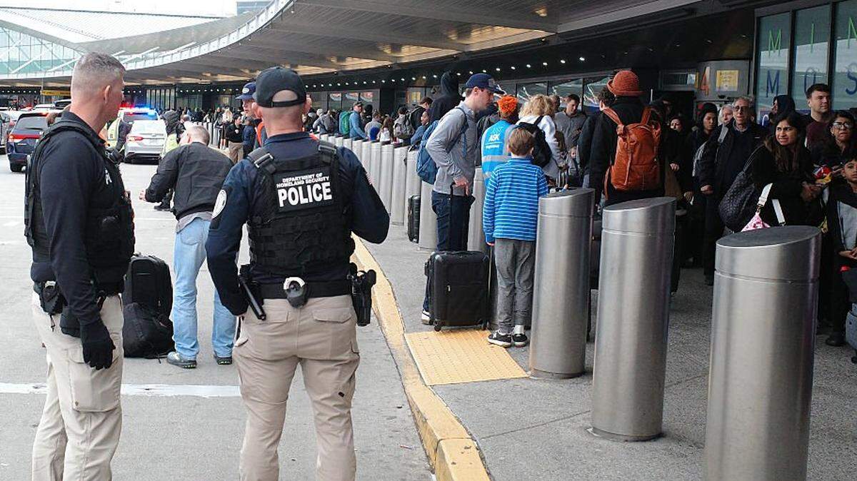 Agentes del Departamento de Seguridad Nacional montan guardia mientras las personas hacen fila para pasar el control de seguridad en la Terminal 5 del Aeropuerto Internacional John F. Kennedy, el 27 de marzo de 2026, en Nueva York, Nueva York. El Senado aprobó por unanimidad la financiación para el Departamento de Seguridad Nacional, excluyendo los fondos destinados a la aplicación de las leyes de inmigración y a las operaciones de deportación.