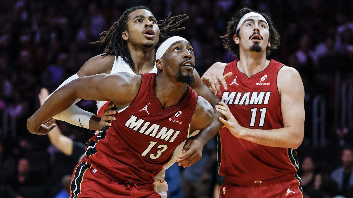 Los jugadores del Heat Bam Adebayo (13) y  Jaime Jáquez Jr. luchan por un rebote con Collin Murray-Boyles, de los Raptors de Toronto, en el partido celebrado el  23 de diciembre de 2025 en Miami.
