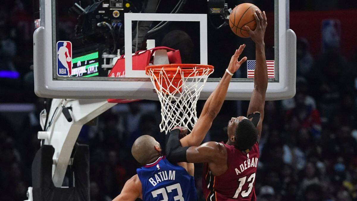 El jugador de los Clippers Nicolas Batum (izq.) trata de bloquear el tiro del centro del Heat de Miami Bam Adebayo, en el partido celebrado el 2 de enero de 2023 en Los Angeles.
