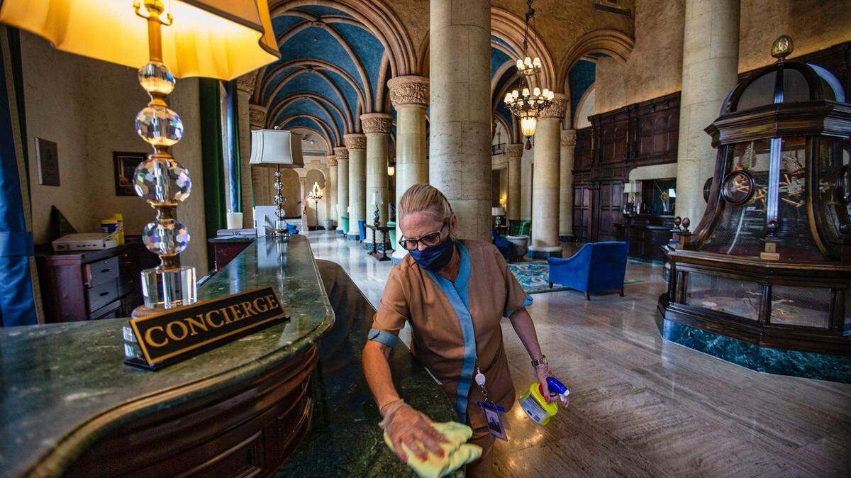 Hilda Castillo, de 62 años, asistente del Hotel Biltmore, desinfecta el área de conserjería del lobby del hotel antes de su apertura el 1 de junio de 2020.