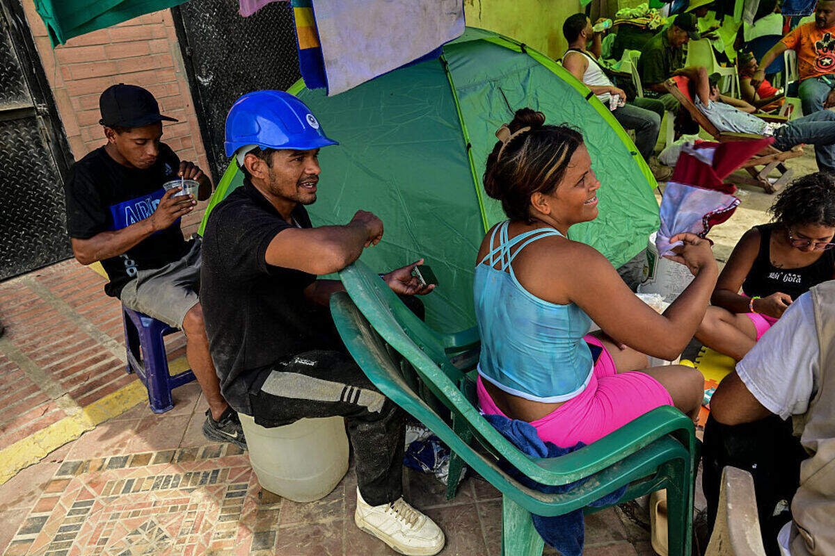 Miguel Báez (segundo de izq. a der.), un rescatista voluntario, está sentado con familiares en un campamento improvisado frente al edificio de apartamentos colapsado donde vivía su familia en Caraballeda, estado La Guaira, Venezuela, el domingo 12 de julio de 2026.