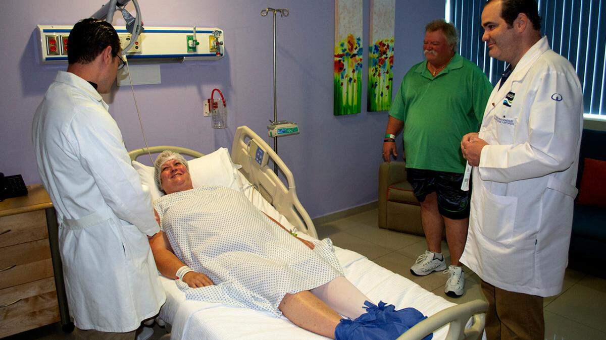 Donna Ferguson, centro, de Ecru, Mississippi, no tuvo contacto previo con el cirujano Thomas Parisi, izq., antes de encontrarse en Cancún, el día antes de tener la cirugía de reemplazo de rodilla. 