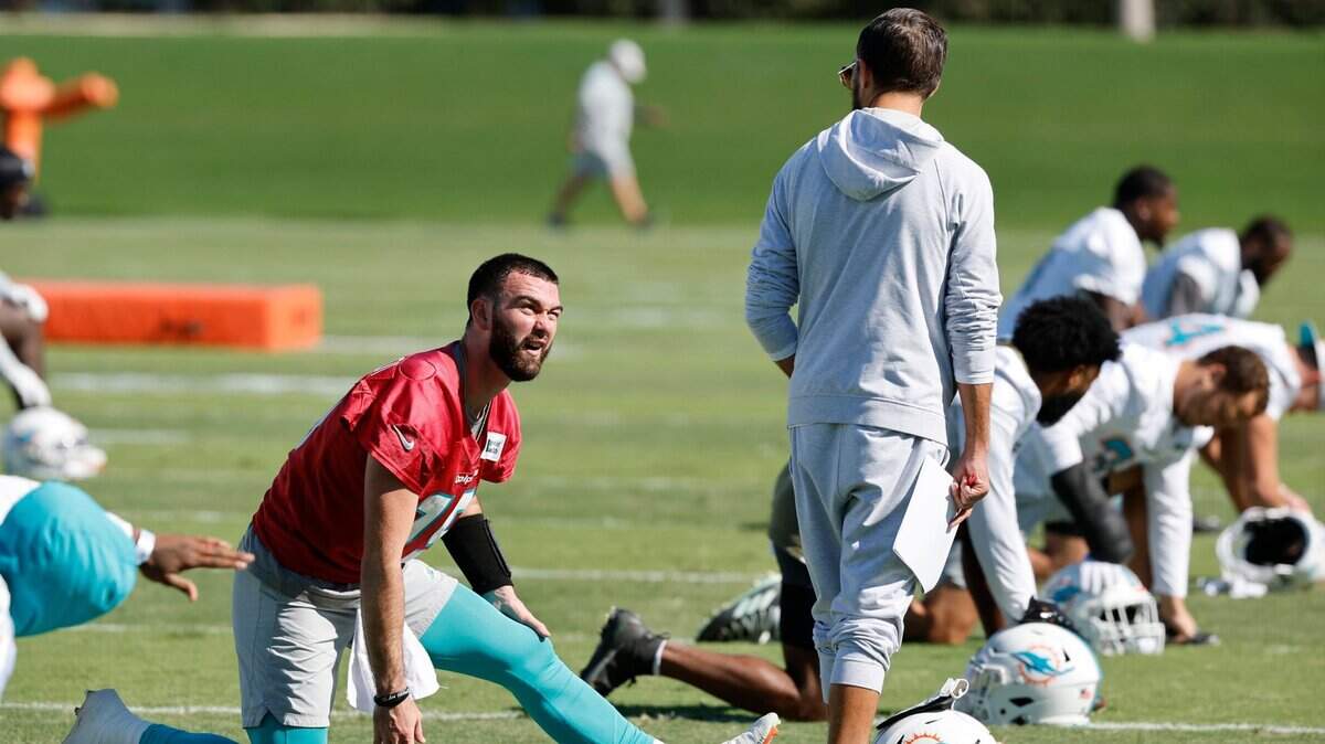 El entrenador de los Dolphins Mike McDaniel habla con el quarterback Skylar Thompson durante una práctica del equipo el 11 de enero de 2023 en Miami Gardens.