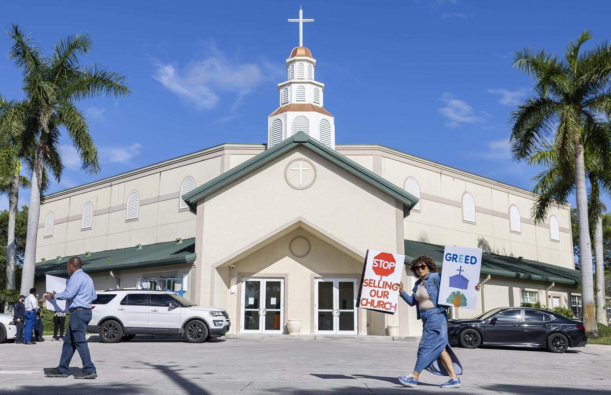 Los feligreses sostienen carteles mientras protestan frente a la Iglesia Casa de Dios en Pompano Beach. Miembros de congregaciones del sur de la Florida organizaron la protesta tras enterarse de que iglesias con una larga trayectoria se estaban vendiendo en una gran reorganización de las iglesias.