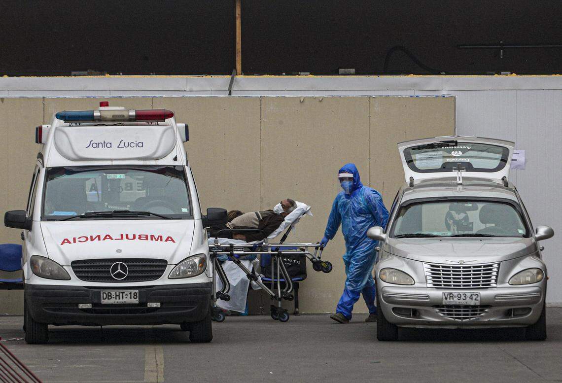 Health workers wear protective equipment against the new coronavirus while moving a patient between an ambulance and a hearse at the San José Hospital in Santiago, Chile, on Wednesday, May 17, 2020.