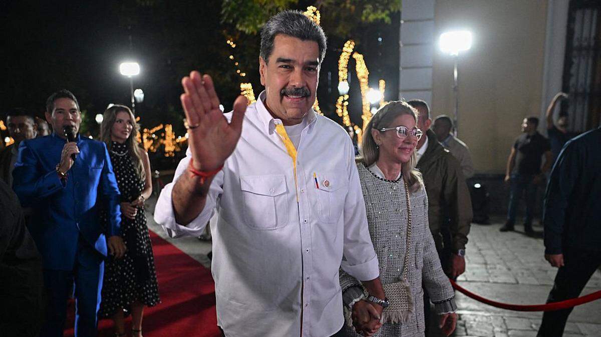 Venezuela's President Nicolas Maduro and his wife Cilia Flores wave to supporters as they arrive for the screening of a biographical series at the National Theatre of Venezuela in Caracas on November 22, 2025. (Photo by Juan BARRETO / AFP via Getty Images)