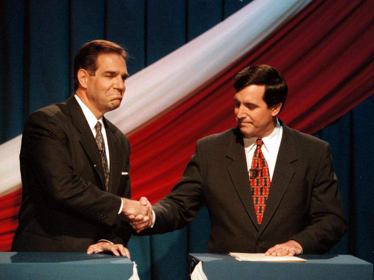 Los dos principales candidatos a la alcaldía de Miami en 1997, Xavier Suárez (izq) y Joe Carollo (dcha), se dan la mano mientras evitan la mirada del otro el 24 de octubre de 1997.