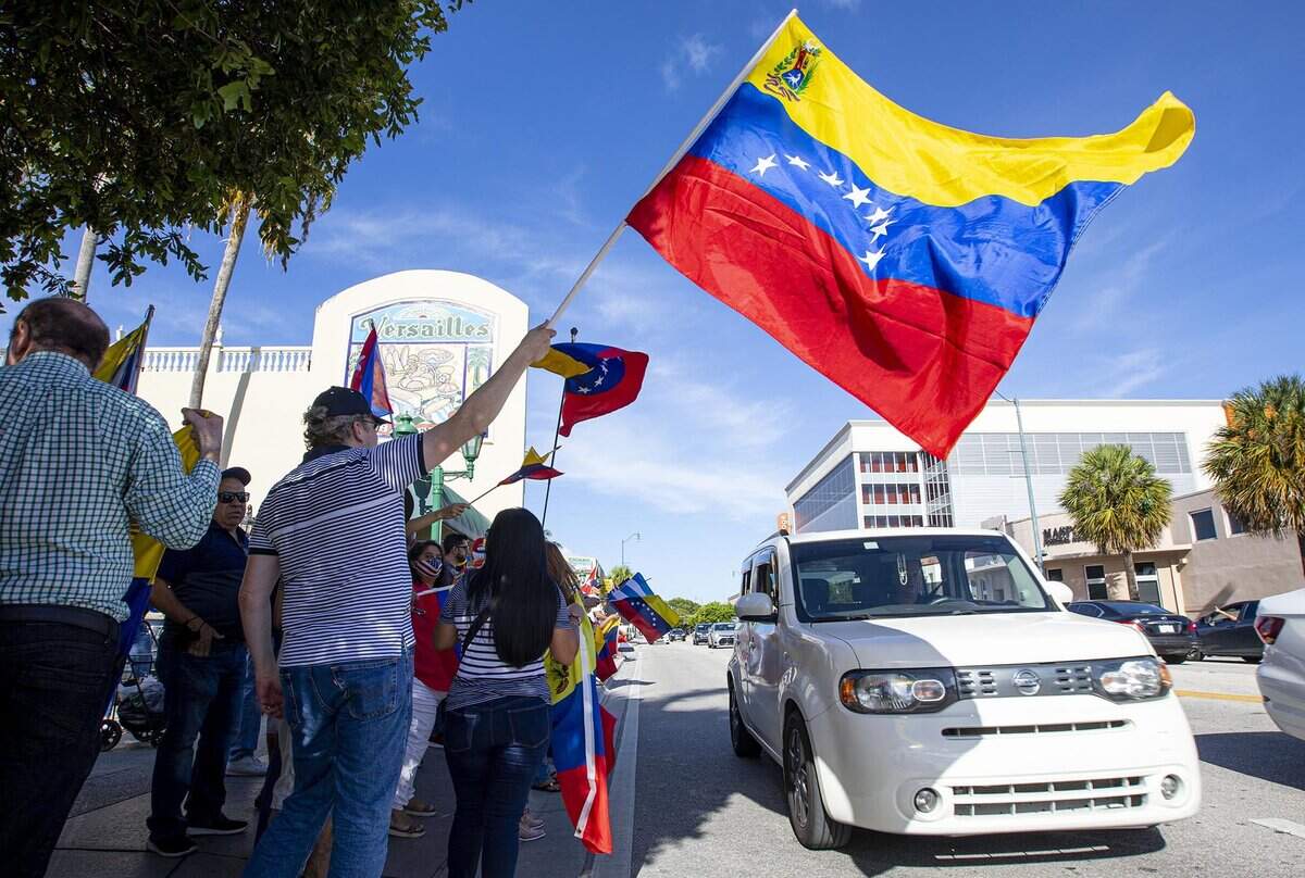 Raimundo Molina ondea una bandera venezolana durante una protesta conjunta entre cubanos y venezolanos en apoyo a la libertad de los cubanos, en Miami, Florida, el domingo 18 de julio de 2021.
