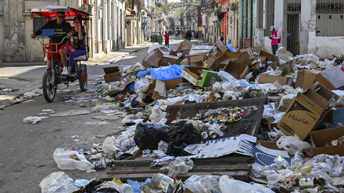 Foto de archivo. Un bicitaxi pasa junto a montones de basura en una calle de La Habana el 17 de febrero de 2026.