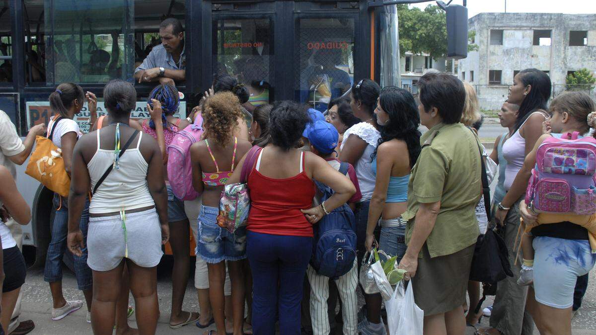 Un grupo de pasajeros espera su turno para abordar un omnibus en una de las calles de La Habana.