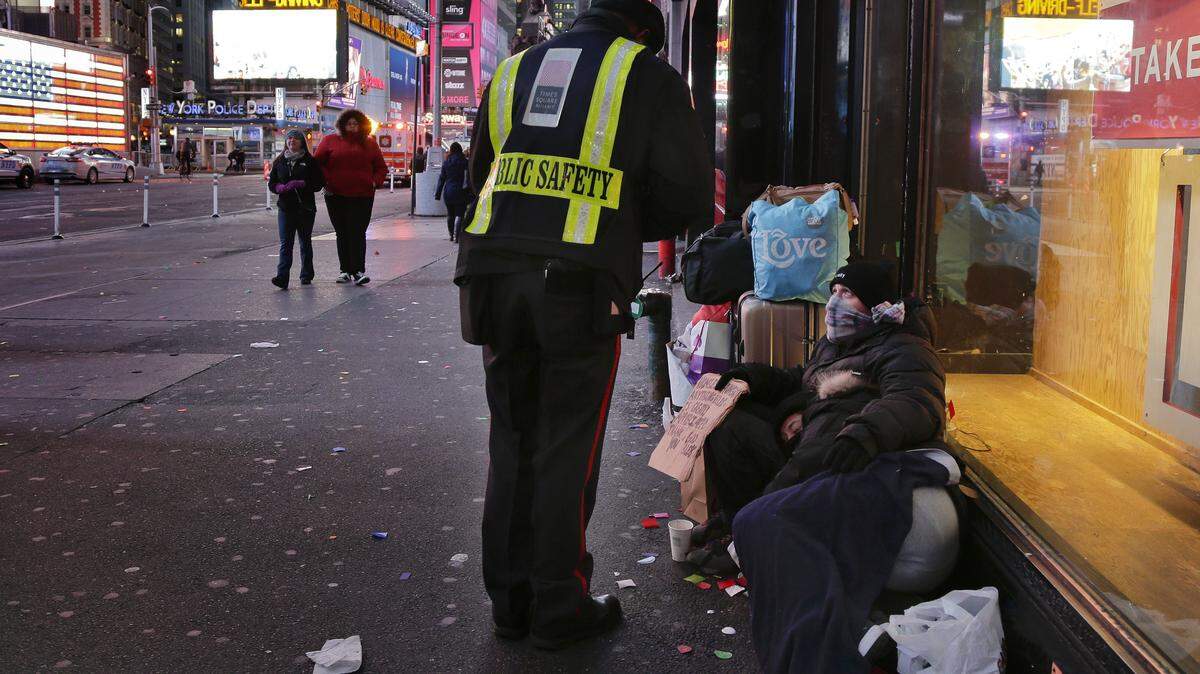 Un oficial de seguridad pública habla con una pareja de desamparados en Time Square, Nueva York, en enero de 2016.