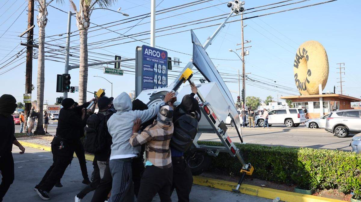 
 Manifestantes destruyen un puesto móvil de vigilancia policial durante un enfrentamiento con agentes federales tras una redada realizada por el Servicio de Control de Inmigración y Aduanas (ICE) en Paramount, California, EE.UU., el 7 de junio de 2025. 