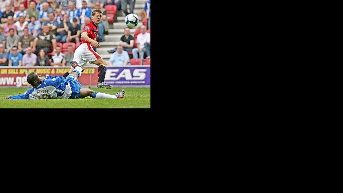 EL INGLES del Manchester United Michael Owen (der.) marca el cuarto gol del equipo contra el Wigan Athletic por la Premier.