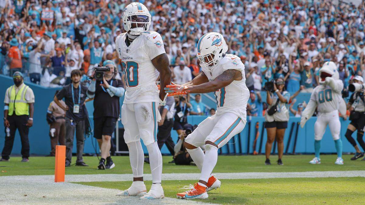 El wide receiver de los Dolphins, Tyreek Hill (izq.), coloca sus manos detrás de la espalda como si estuviera esposado mientras su compañero de equipo, Jaylen Waddle, hace como si se las quitara, luego de anotar un touchdown contra los Jaguars de Jacksonville, en el partido celebrado el 8 de septiembre de 2024 en el Hard Rock Stadium en Miami Gardens, Florida.