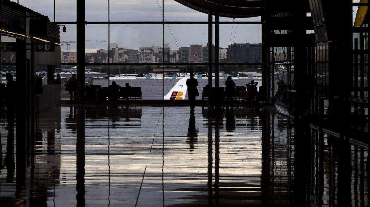 FILE - En esta foto de archivo del viernes 9 de noviembre del 2012, pasajeros se paran frente al aeropuerto internacional de Madrid. (AP Photo/Daniel Ochoa de Olza, File)