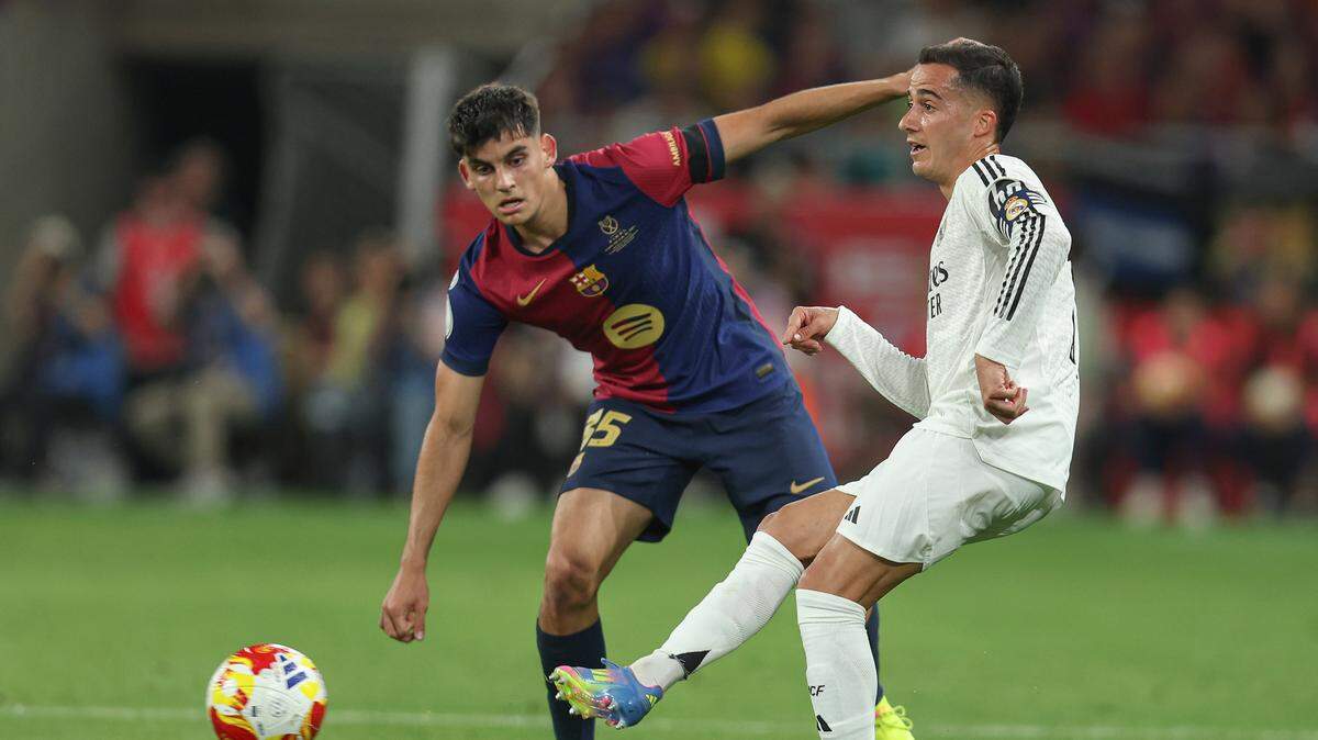 El jugador de Real Madrid Lucas Vázquez (der.) pasa la pelota ante la marca de Gerard Martín, del Barcelona, durante el partido celebrado el 26 de abril de 2025 en Sevilla.