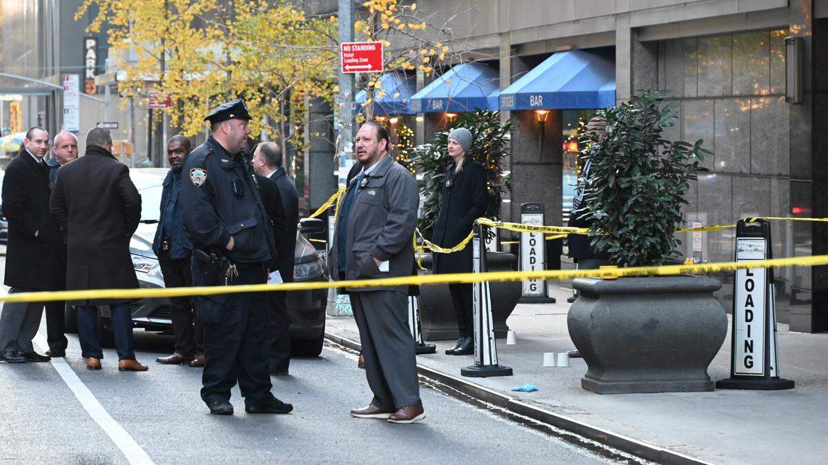 AGENTES POLICIALES rodean el área en donde fue asesinado a disparos el director ejecutivo de UnitedHealthcare, Brian Thompson.