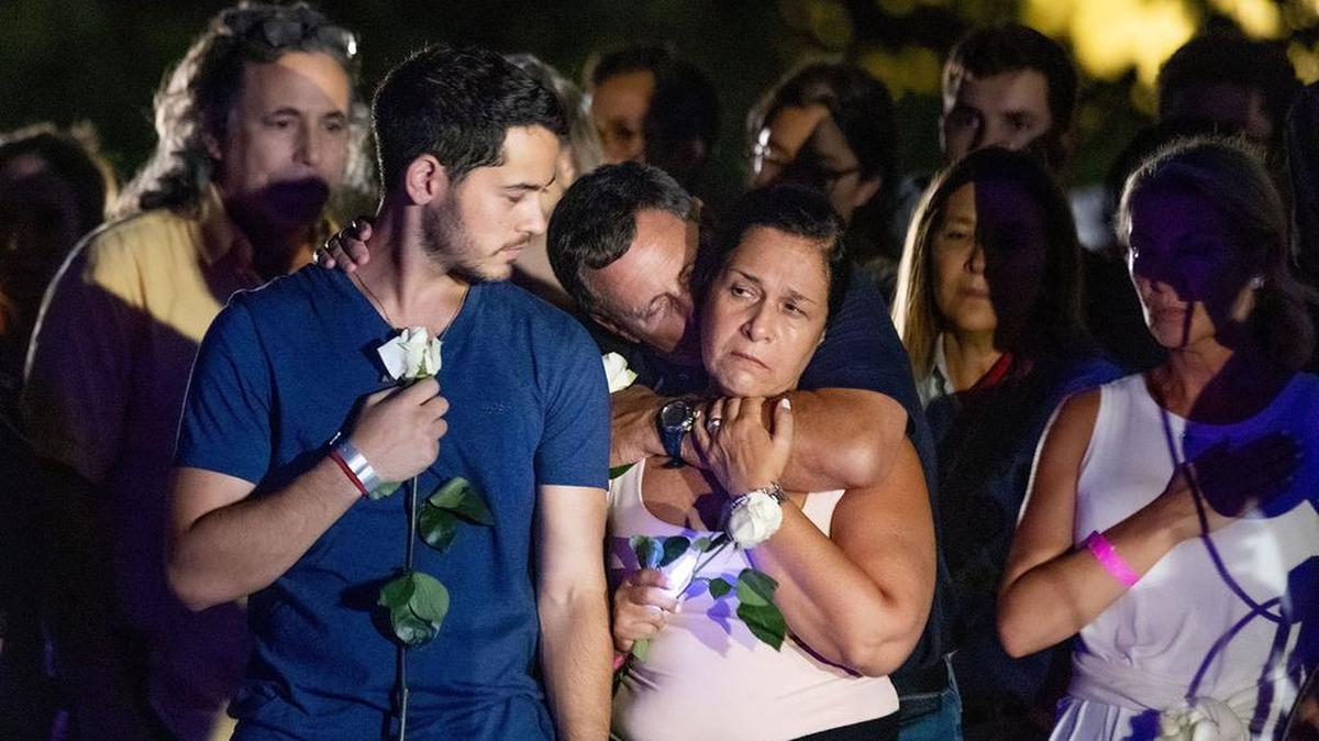 People attend a community vigil on the beach for the missing and deceased after the partial collapse of Champlain Towers South condo in Surfside.