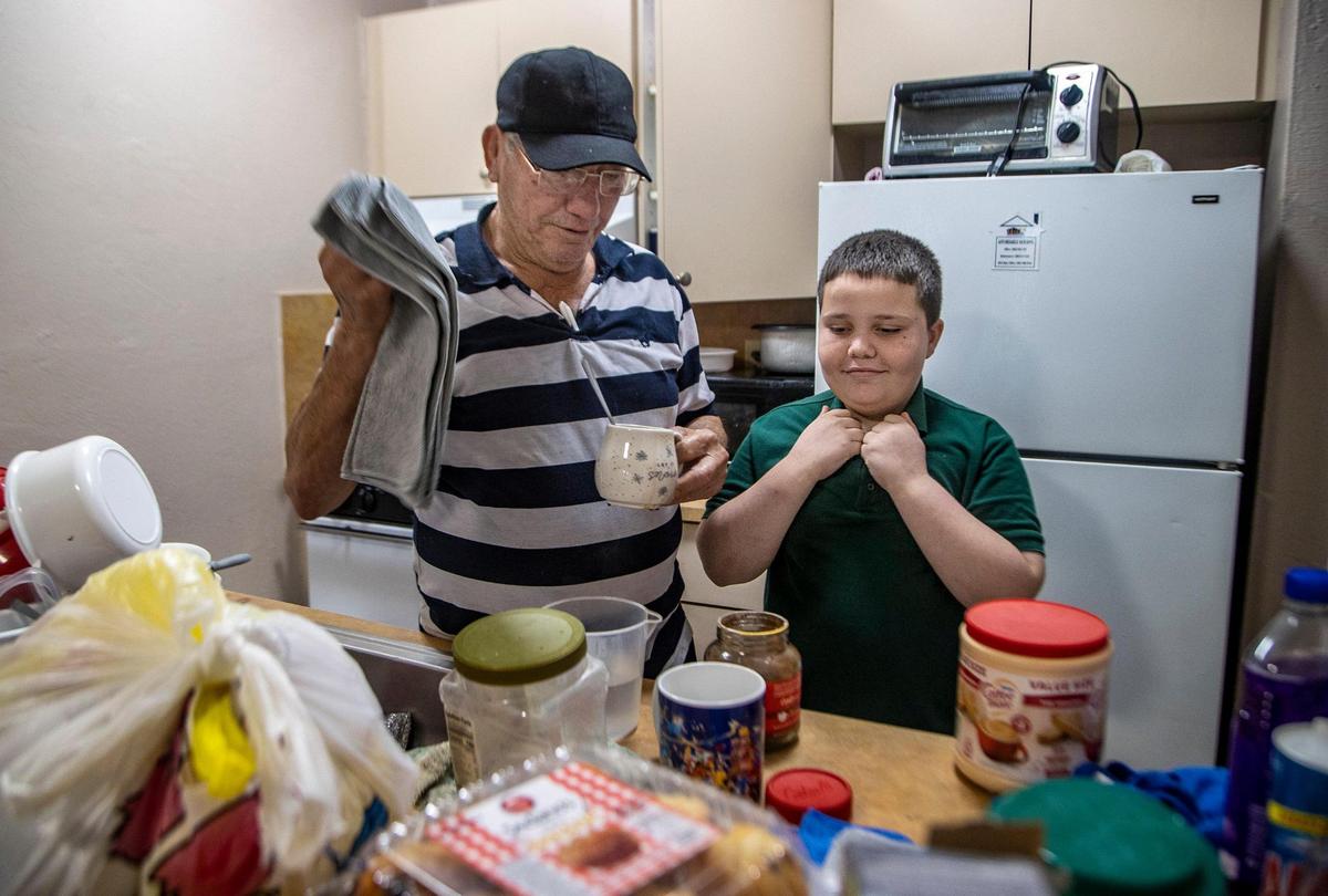 Concepción Gutiérrez makes coffee with his son Concepción Iván Gutiérrez, 9, in the kitchen of their Hialeah apartment. Mr. Gutiérrez is disabled due to health problems.