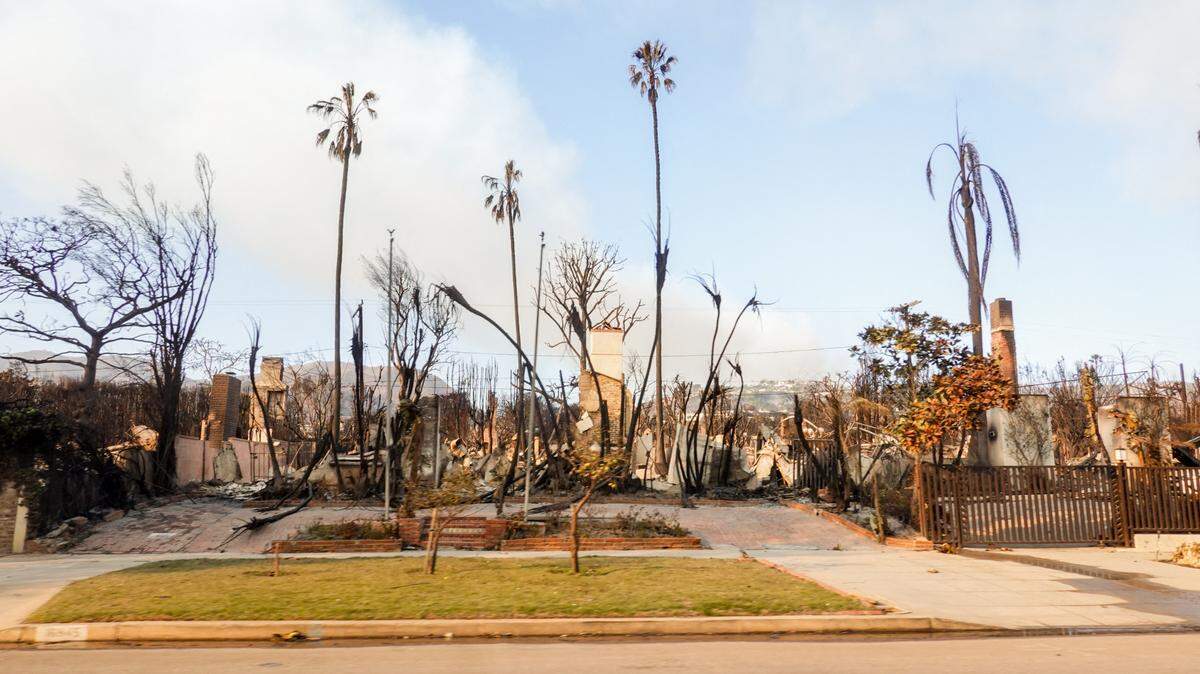 Arboles quemados y escombros bordean una calle devastada en Pacific Palisades, Los Angeles, California, el 11 de enero de 2025, mientras los incendios forestales continúan en el condado de Los Angeles.
