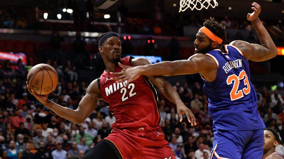 El jugador del Heat Jimmy Butler (izq.) trata de pasar la pelota ante la marca de Mitchell Robinson, de los Knicks de New York, en el partido celebrado el 26 de enero de 2022 en Miami.