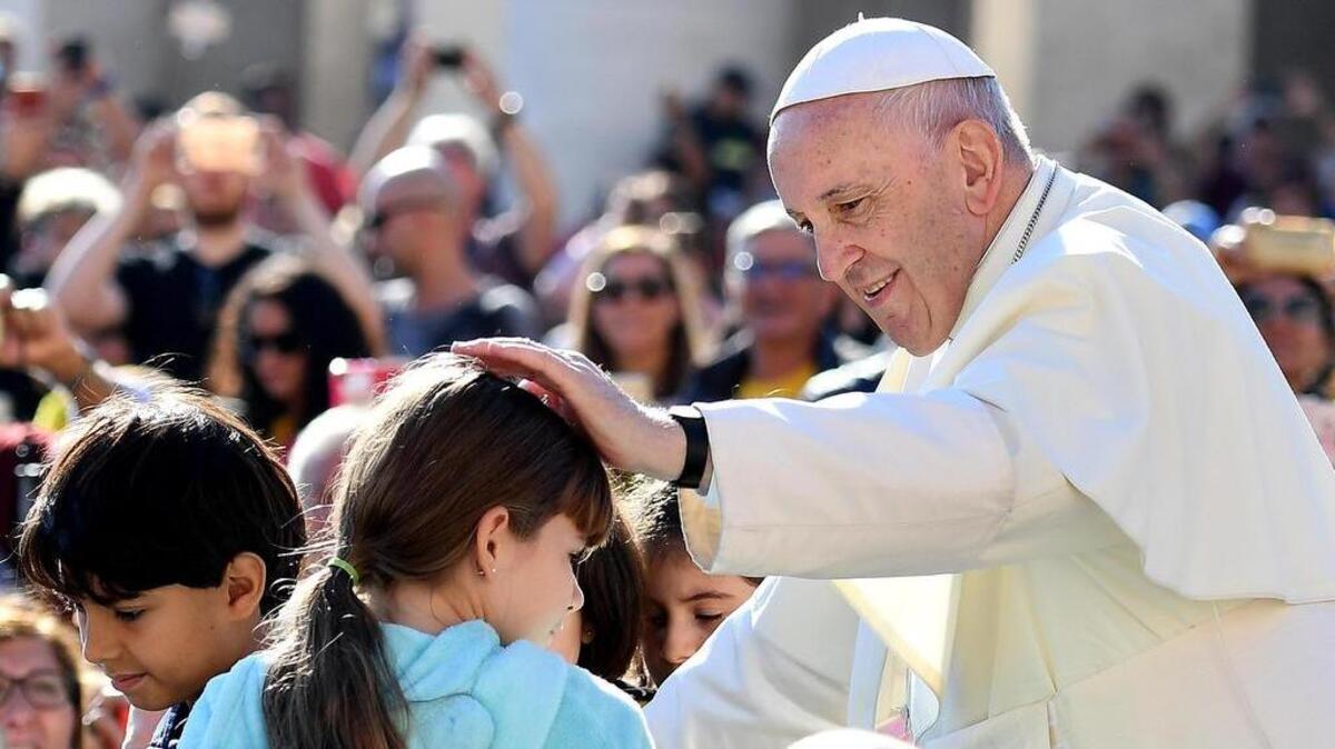 El papa Francisco (d) bendice a una niña durante su tradicional audiencia semanal en la Plaza de San Pedro del Vaticano, el 10 de octubre de 2018.