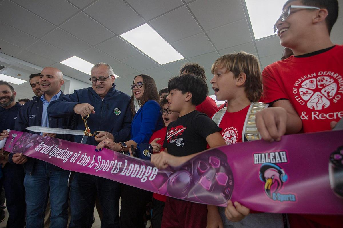 (Centro) El alcalde de Hialeah, Esteban Bovo corta el listón, (derecha) Sean Palmer, 10; Dylan Cuenca, 10; René Román, 11; y Alejandro Ramírez, de 16 años; cuando la ciudad abre su primer salón de deportes electrónicos en Cotson Park, Hialeah, el viernes 22 de marzo de 2024.