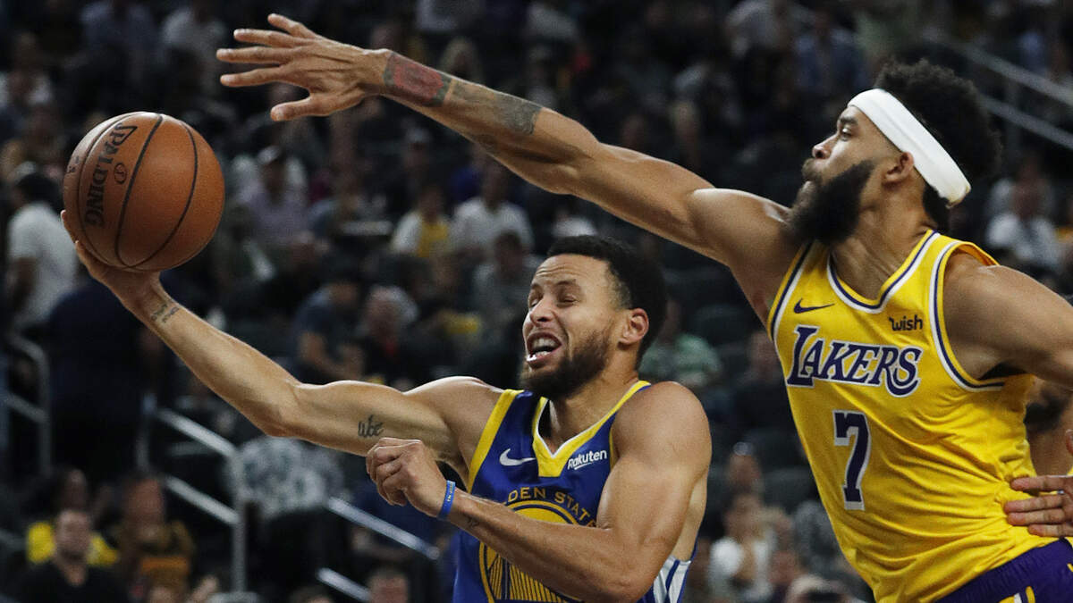 El escolta de los Warriors Stephen Curry tira al aro ante la marca de JaVale McGee, de los Lakers, el 10 de octubre de 2018.