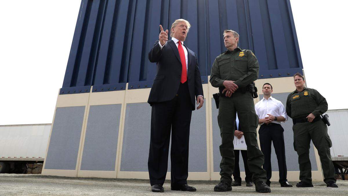 El presidente Donald Trump conversa con Rodney Scott, jefe de la Patrulla Fronteriza en San Diego, durante su visita al lugar donde están construyendo prototipos del muro fronterizo, el 13 de marzo de 2018, en San Diego, California.