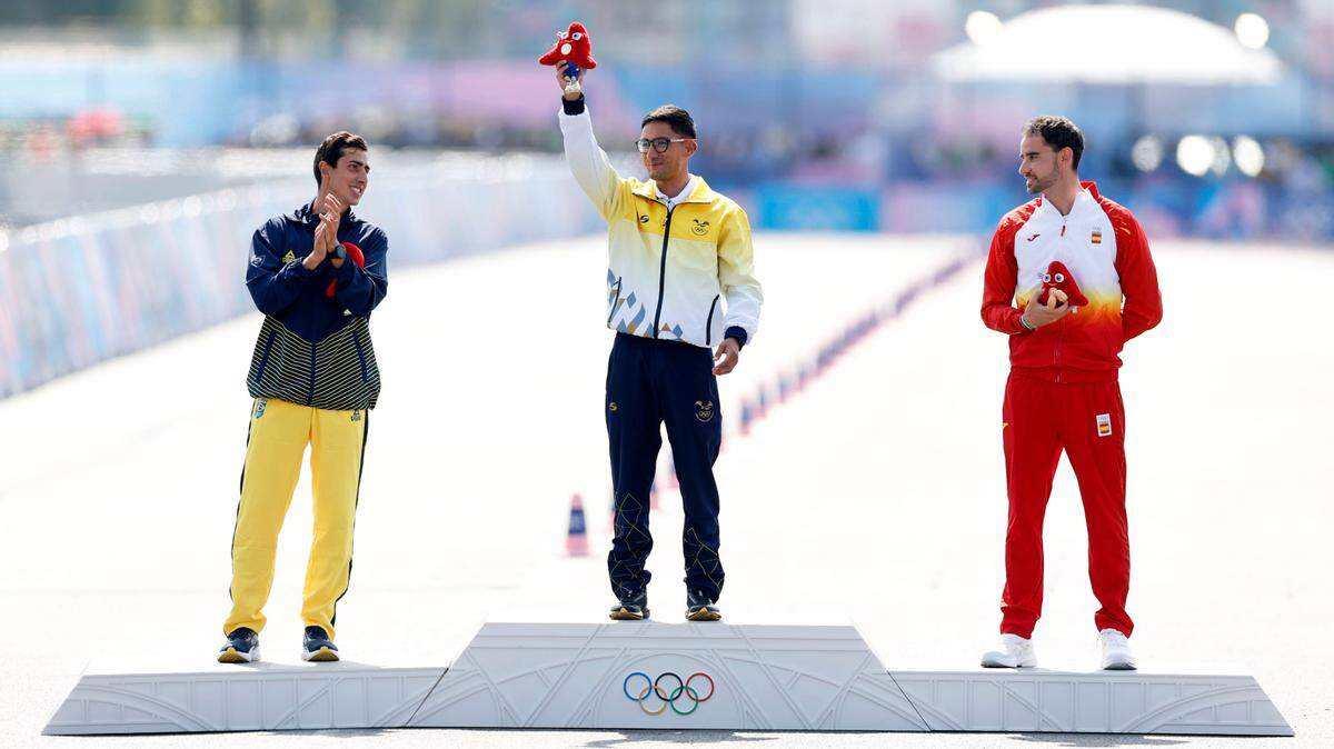 El ecuatoriano Daniel Pintado (centro) saluda en el podio tras ganar la medalla de oro en la marcha de 20 kilómetros en los Juegos de París. El brasileño Caio Bonfim (izq.) obtuvo la presea de plata y el español Álvaro Martín el bronce.