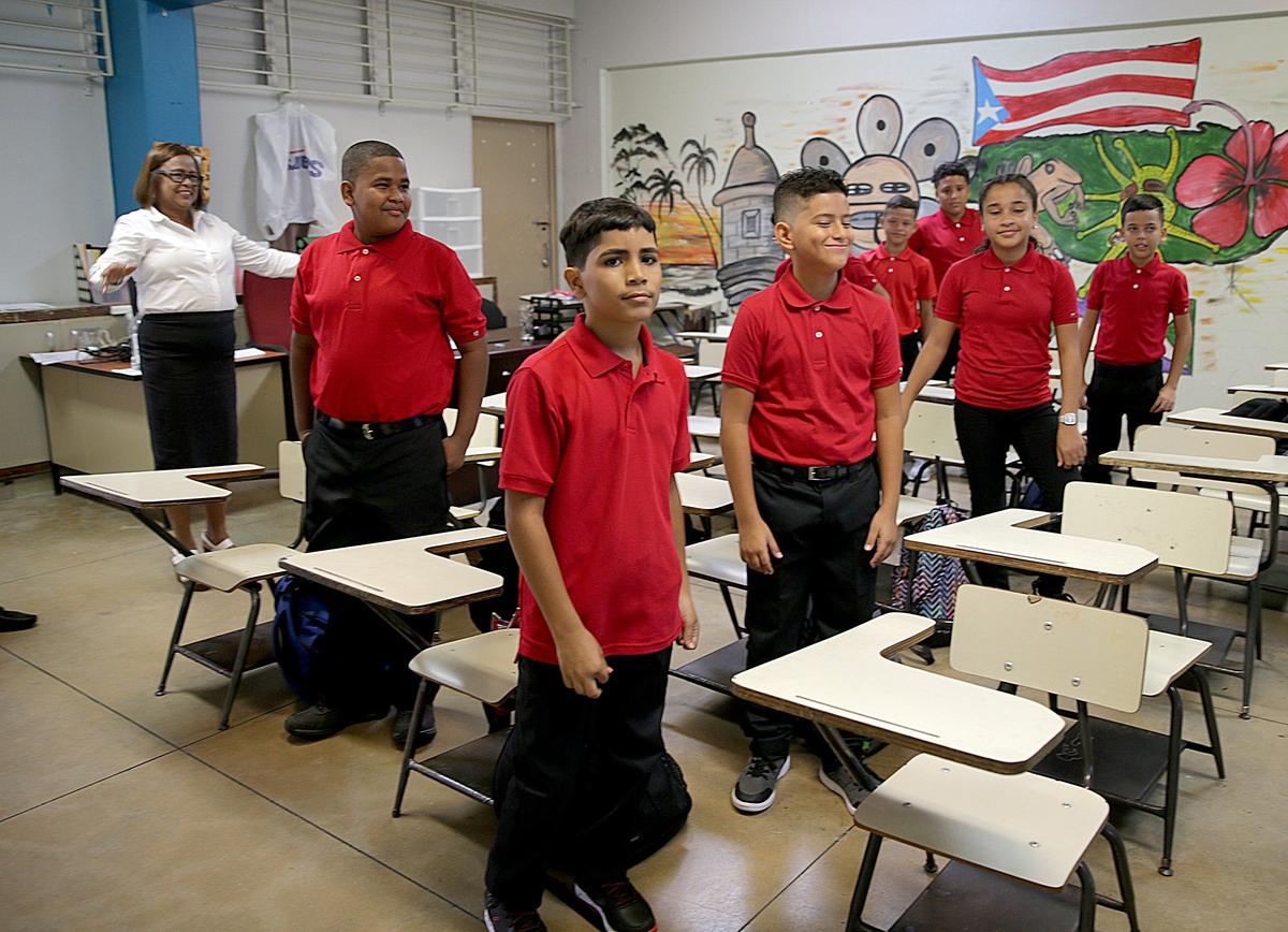 La directora Victoria García Burgos da la bienvenida a los alumnos de sexto grado en la escuela intermedia pública Rosa Costa Valdivieso, en el poblado puertorriqueño de Yabucoa, el primer día del curso escolar, este lunes 13 de agosto del 2018.
