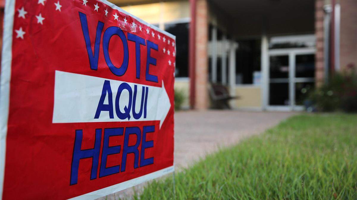 En Austin, Texas, un letrero bilingüe se encuentra frente a un centro de votación en una biblioteca pública antes de una elección.