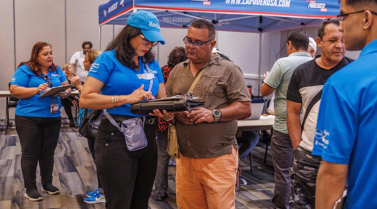 Agente Lisbeth Lazaballet con de la compañía de seguros Las Madrinas asesora a Eduardo Valdés, quien llegó de Cuba hace 10 meses, en la la feria comunitaria llamada “Inmigración y más” patrocinada por la emisora La Poderosa Radio y la Ciudad de Hialeah, para ayudar a la comunidad y principalmente personas que llegaron recientemente a la ciudad para buscar trabajo, seguro médico, escuelas, etc, celebrado en el Milander Center for Arts & Entertainment en Hialeah, el viernes 22 de septiembre de 2023.