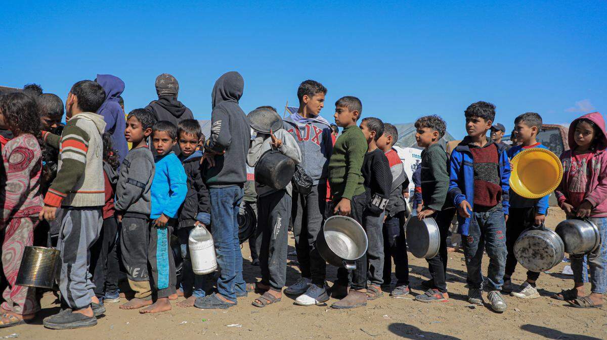 Decenas de niños hacen fila para recibir comida en la ciudad sureña de Rafah, en Gaza, el sábado 10 de febrero de 2024.