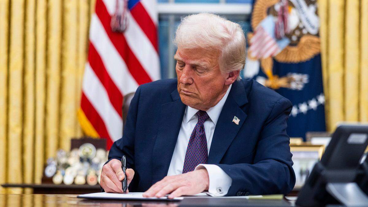 President Donald Trump signs executive orders on his first day in office in the White House Oval Office, in Washington, DC, United States, on January 20, 2025.
