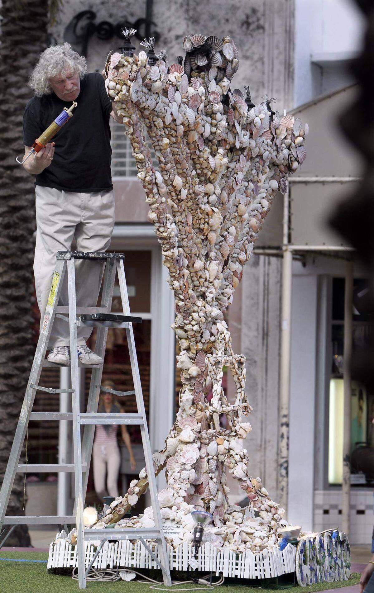 Roger Abramson trabajando en su menorá de conchas en la intersección de Euclid street y Lincoln Road Mall el 19 de diciembre de 2011. Las delicadas conchas que cubrían su superficie a menudo se agrietaban o se desprendían.