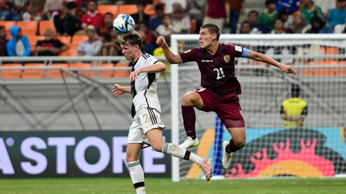 El jugador de Venezuela Nicola Profeta (der.) disputa el balón con Kurt Rueger, de Alemania, en un partido del Mundial sub-17 celebrado el 18 de noviembre de 2023 en Jakarta, Indonesia.