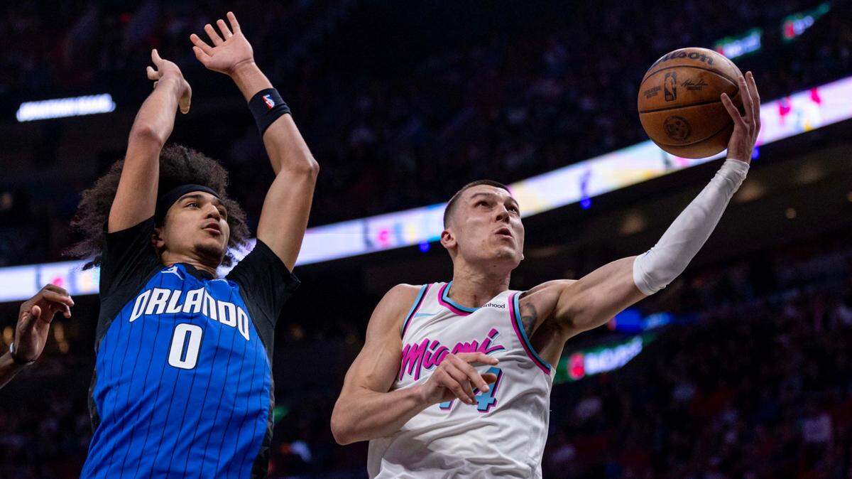 El escolta del Heat, Tyler Herro (der.), entra al aro ante la marca de Anthony Black, del Magic de Orlando, en el partido celebrado el 27 de enero de 2025 en Miami.
