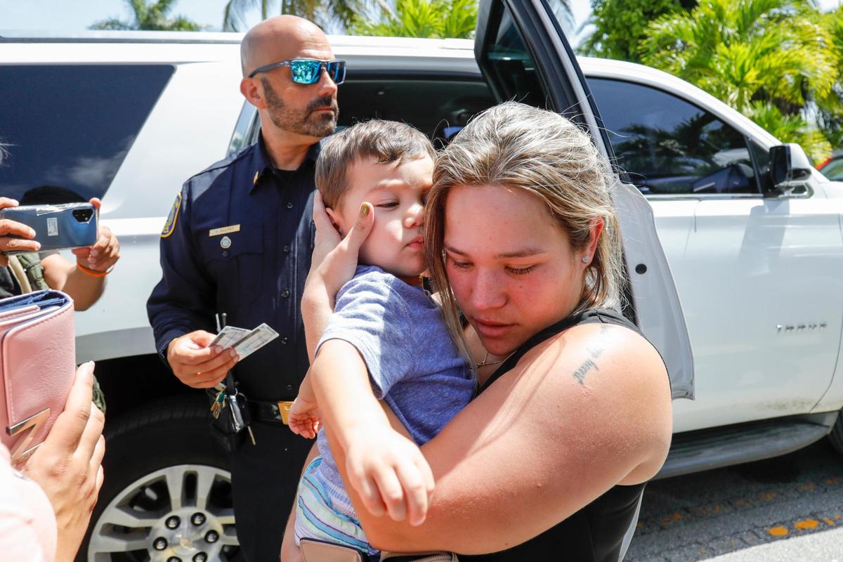 Una mujer se reúne con su hijo después de que la policía de Hialeah pudiera evacuar a siete niños de una guardería cerca de una casa donde un hombre con un rifle de asalto se atrincheró en 30 East 53rd Terrace en Hialeah, Florida, el jueves 28 de julio de 2022.